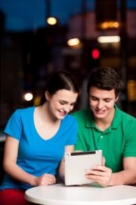 Couple Using Digital Tablet In Cafe